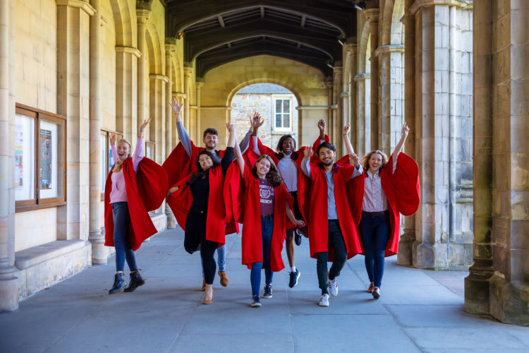 Red-Gowns-Hands-Up-Cloisters-landscape
