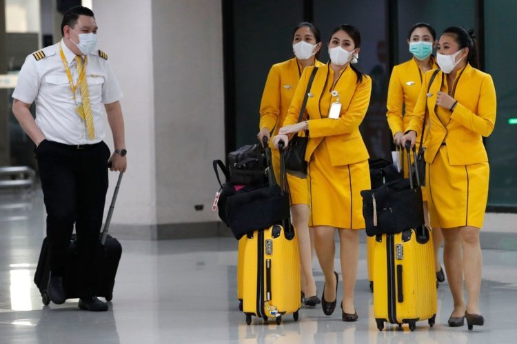 Asian flight crew wear masks coming through an airport