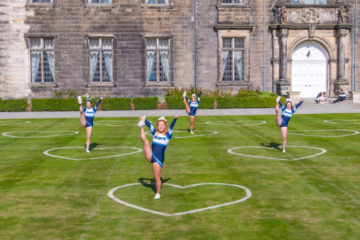 Four Saints Cheerleaders standing alone in love hearts on St Salvador's quad.