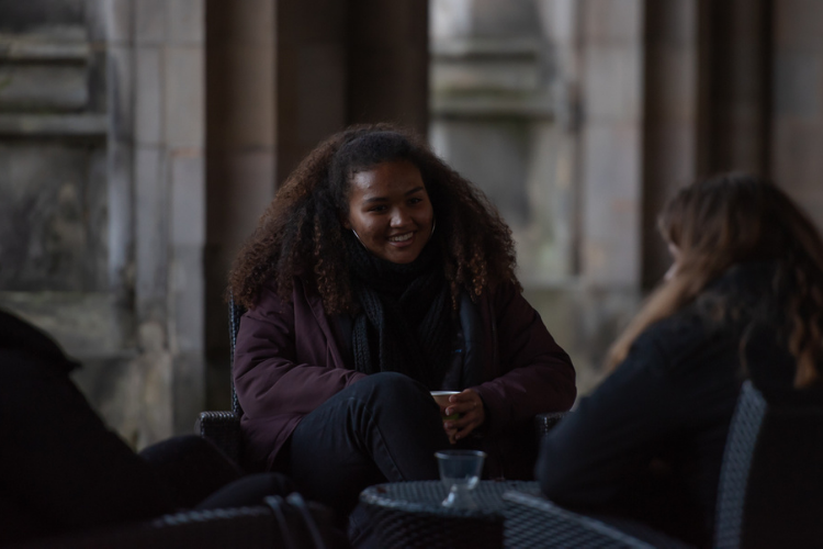 Student sitting with friends in St Salvator quad
