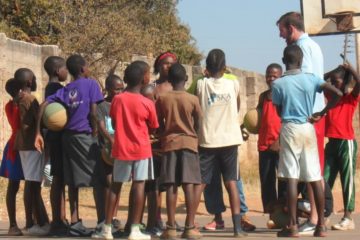 Zambian children being coached while playing Basketball