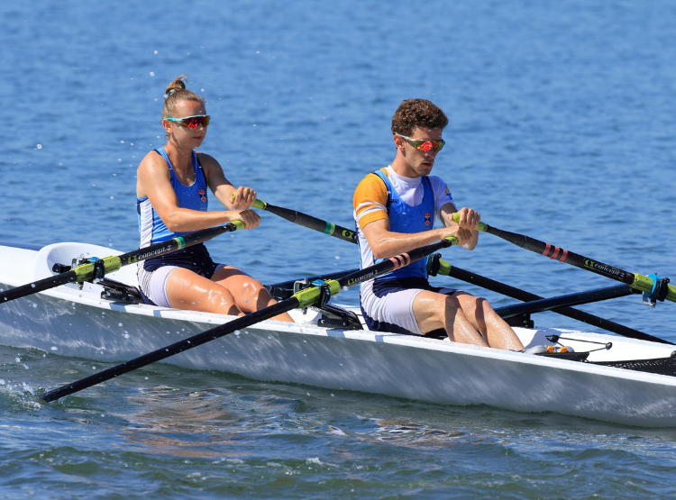 Two people rowing a boat on open water