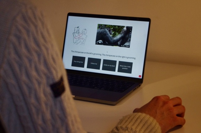 A laptop with a quiz on screen, with a person's arm and hand visible, as if going to take part