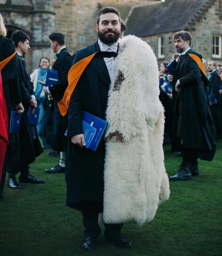 Student in academic dress wearing a wool cloak