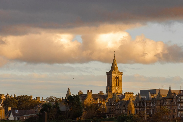 View of old houses with chapel steeple against a clouded sky