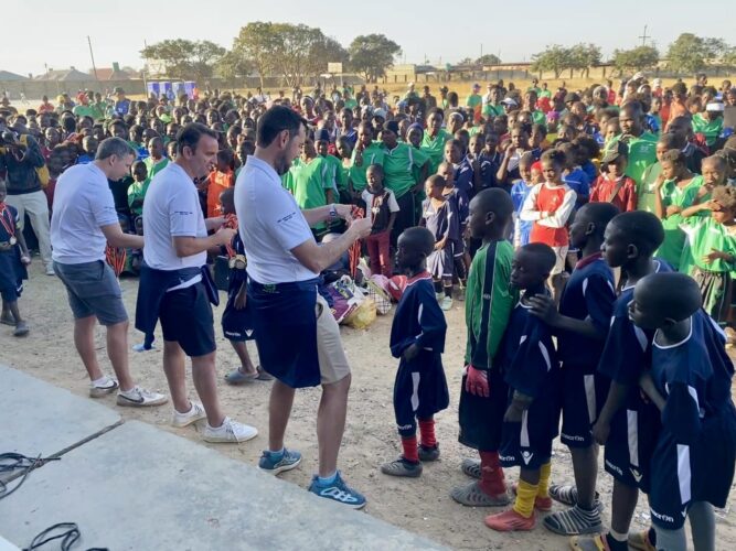Children in sports kit line up to receive medals