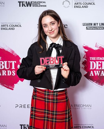 smiling young woman in a kilt holding an award